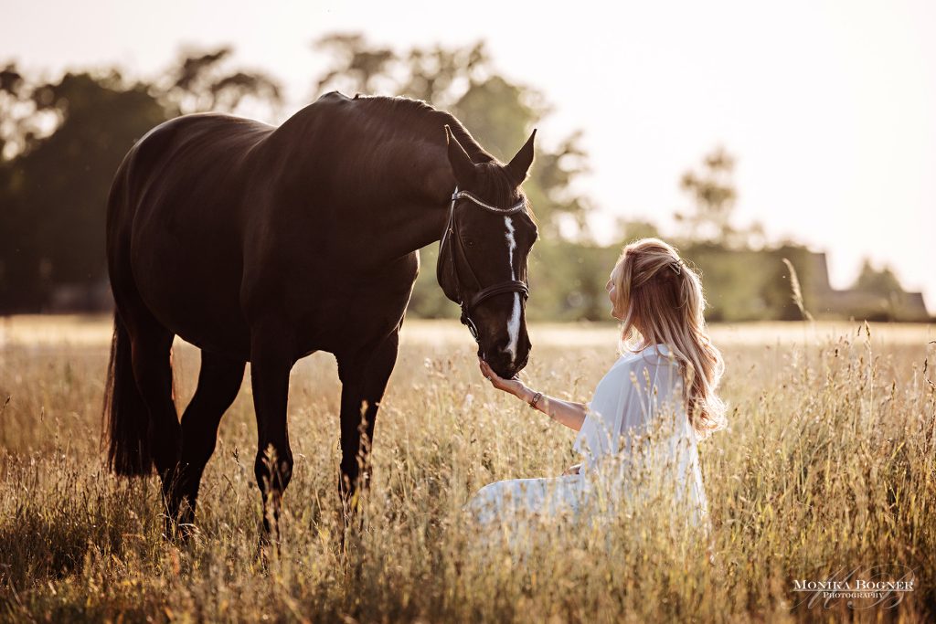 Milena Joerger füttert ein Pferd auf der Weide im Sommer - eine enge Verbindung
